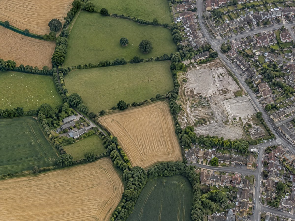 Aerial view of English farmland meeting a brownfield plot
